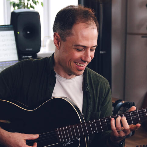 Portrait image of Bradley Kunda playing a guitar Portrait image of Bradley Kunda playing a guitar